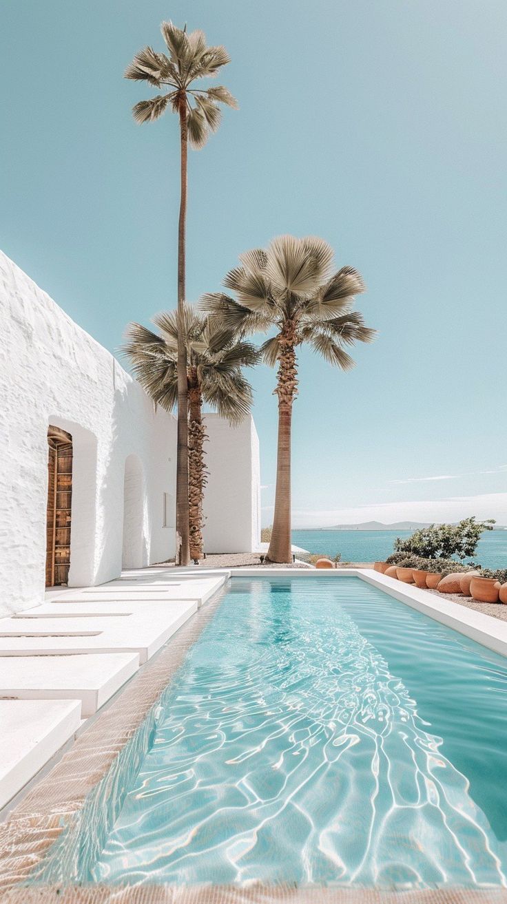 Tranquil white villa with palm trees overlooking a turquoise pool